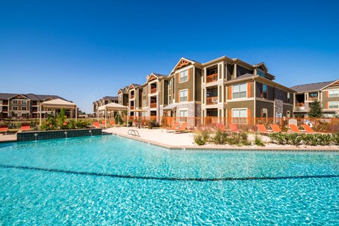 A large building with a pool in front of it.