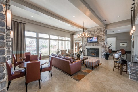 A living room with a stone fireplace and a flat screen TV mounted above it.