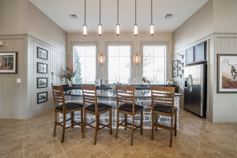A kitchen with a table and chairs in front of a window.