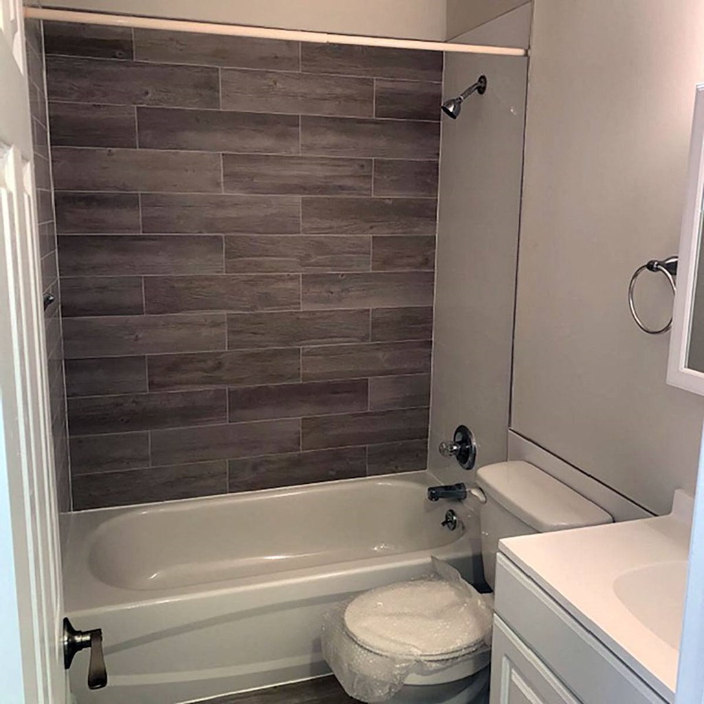 a bathroom with a toilet and a bathtub at Brookwood at Sayville, Sayville, NY