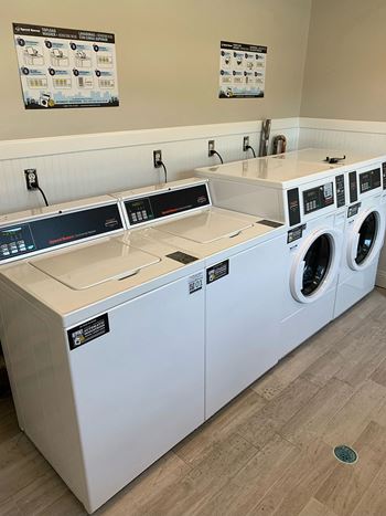 A laundry room with two washers and two dryers  Brookwood at Islip, New York, 11751