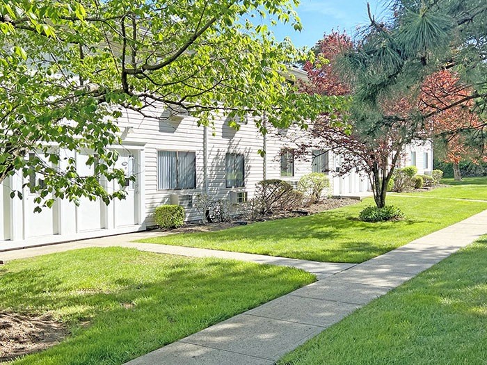 Lush green lawn area in front of apartment building at Brookwood at Ridge, New York