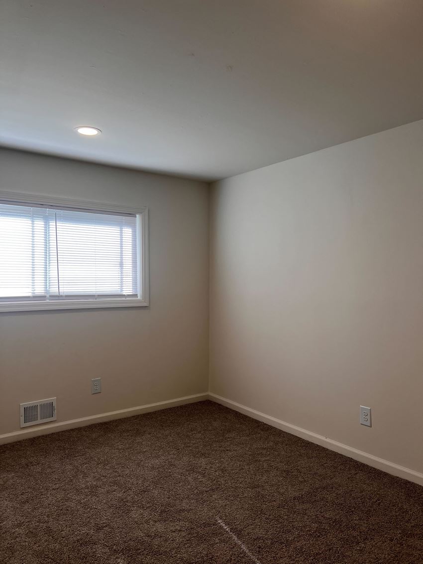 an empty room with a window and a carpet