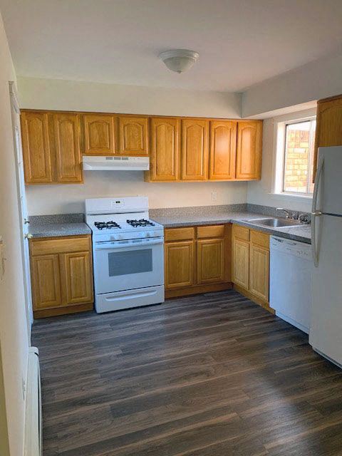 a kitchen with a white stove top oven next to a refrigerator