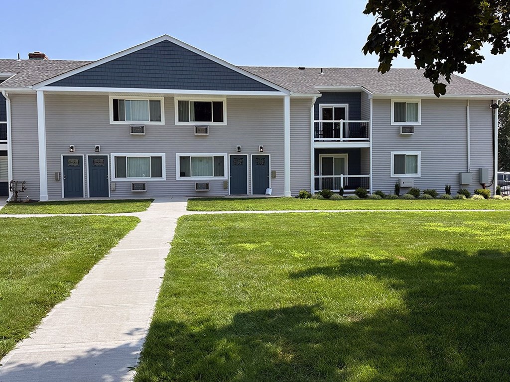 a large gray house with blue doors and windows on a sunny day at Brookwood at Sayville, Sayville