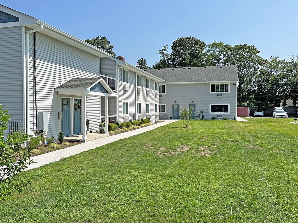 a grassy yard in front of a building at Brookwood at Sayville, Sayville, New York