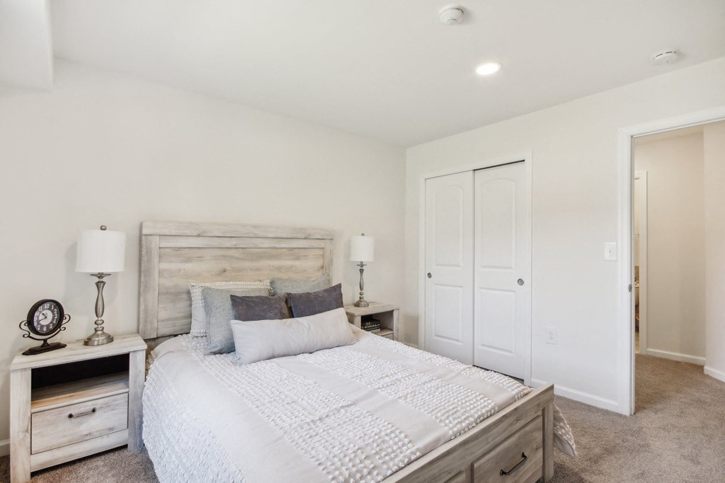 a spacious bedroom with a bed and a closet at Brookwood at Ridge, New York, 11961