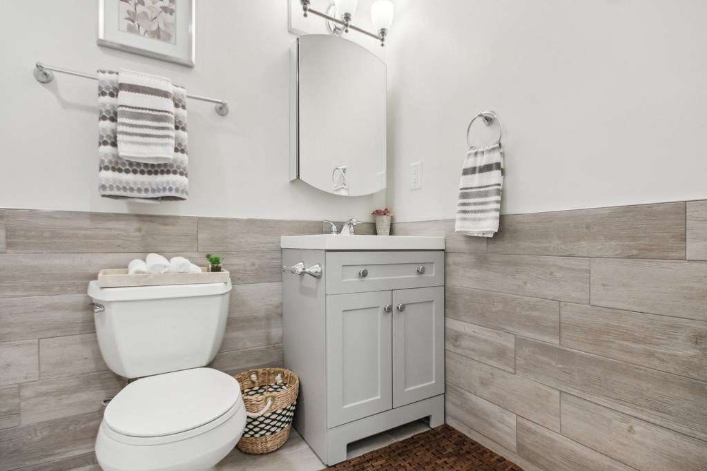 a white bathroom with a toilet and a sink at Brookwood at Ridge, New York, 11961