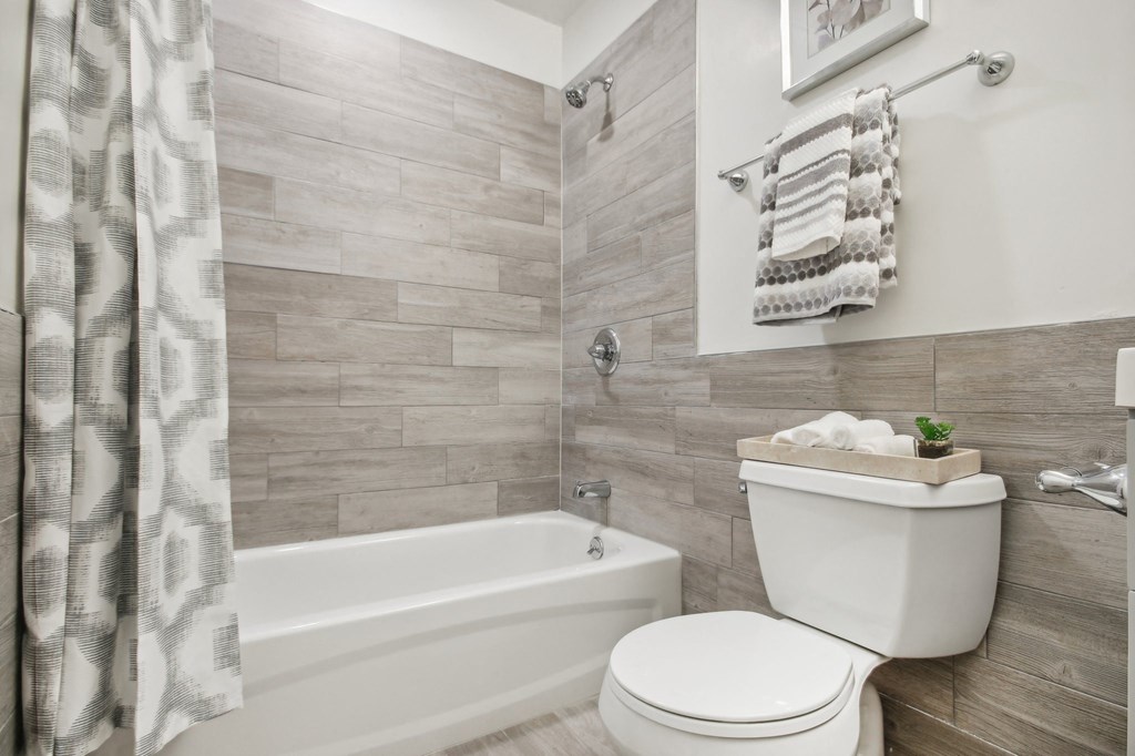 a bathroom with a toilet and a bath tub at Brookwood at Ridge, New York, 11961
