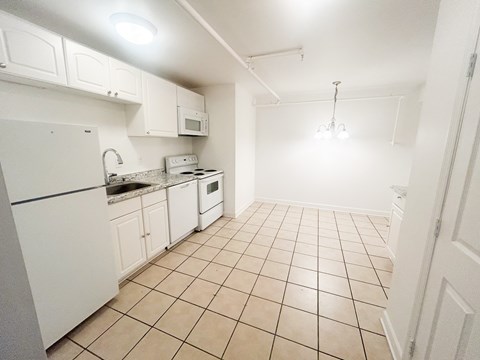 A kitchen with white appliances and cabinets.