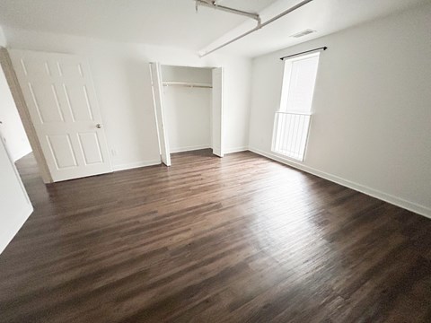 A room with wooden flooring and white walls.