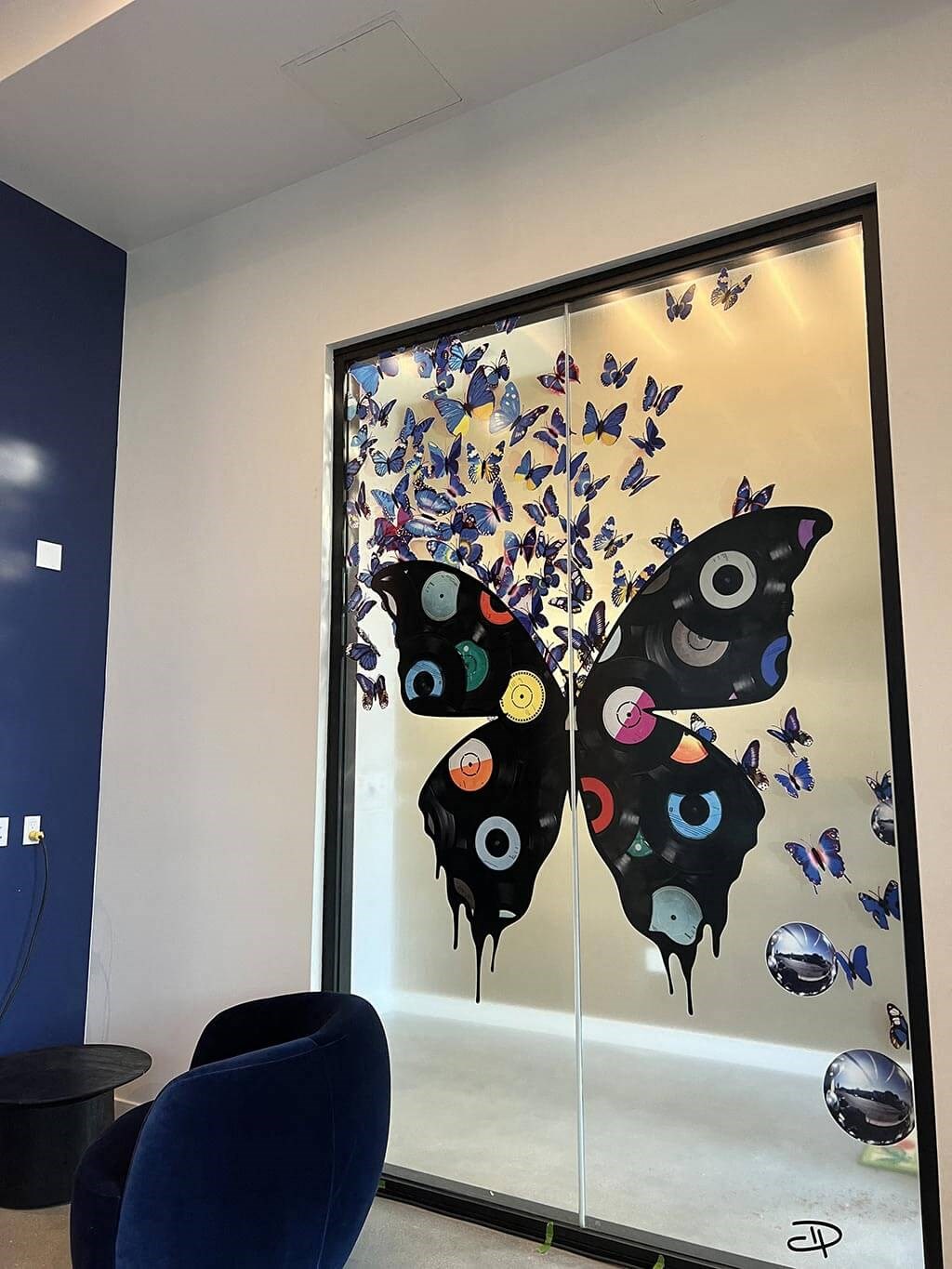 a large glass window with butterflies on it
