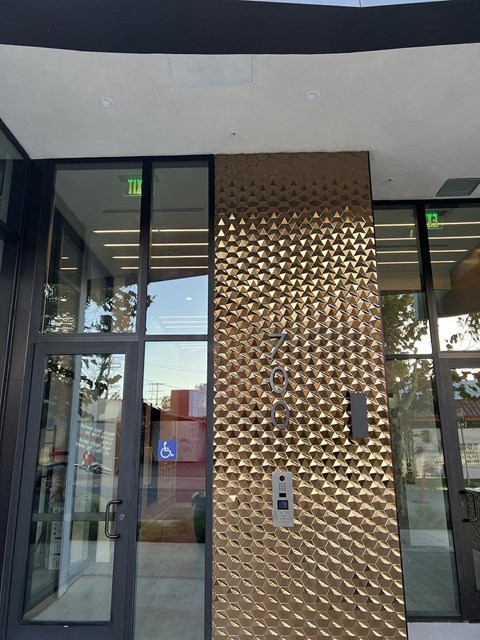 the front door of a building with a gold wall