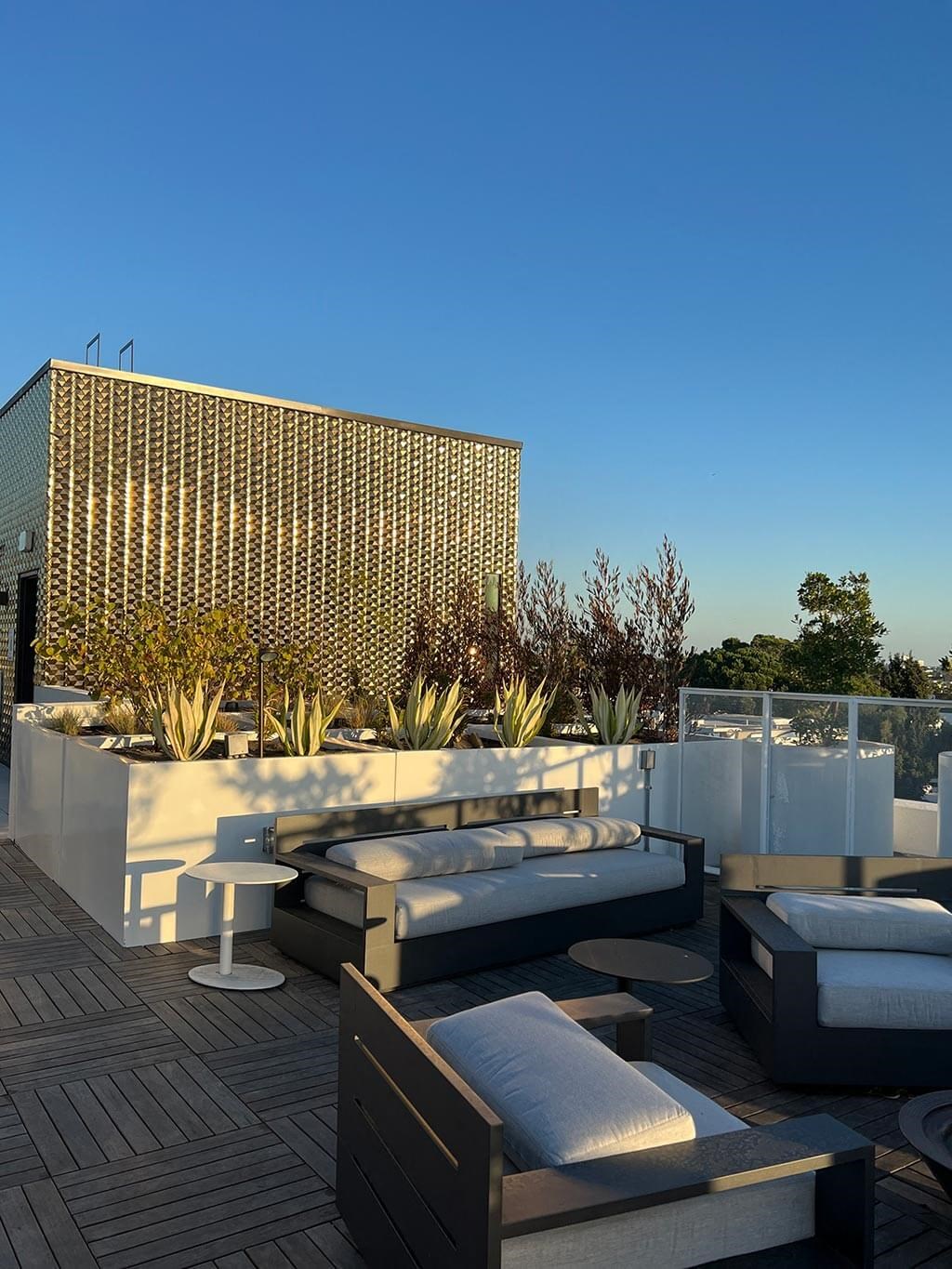 a roof terrace with furniture and a building in the background