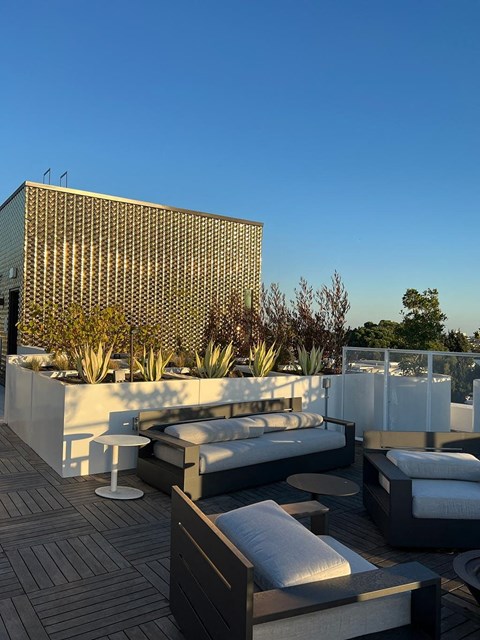 a roof terrace with furniture and a building in the background