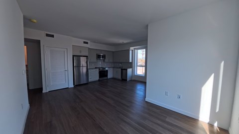 A large empty room with wooden floors and white walls.