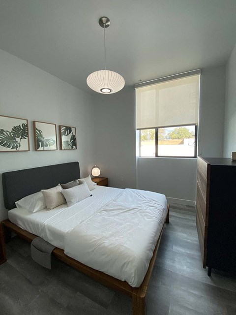 a bedroom with a white bed and a window