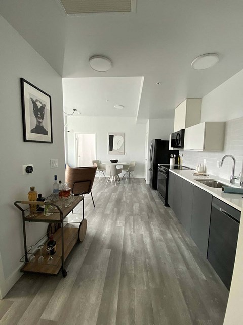 a kitchen and a living room with a wooden floor