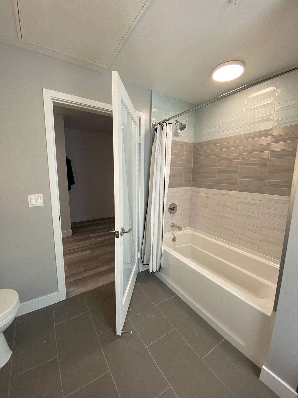 a bathroom with a shower and a toilet and a door