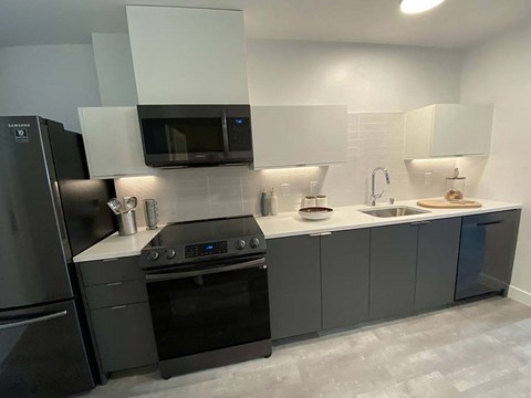 a kitchen with a stove and a sink and a refrigerator