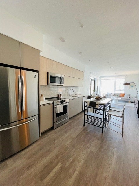 a kitchen with stainless steel appliances and a table and chairs