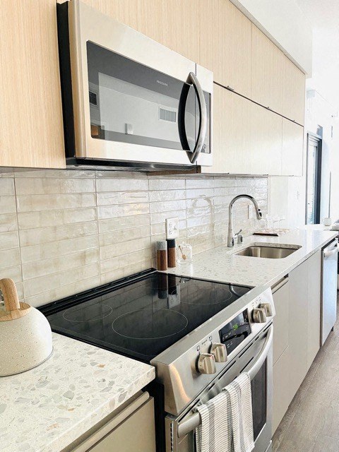 a kitchen with a stove top oven and a sink