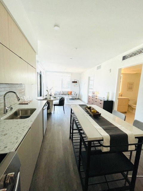 a kitchen with a long table and a sink