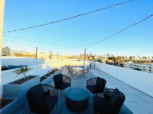 a rooftop patio with a view of the city and a table and chairs