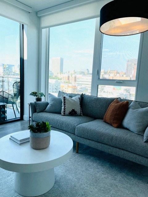 a living room with a gray couch and a white coffee table