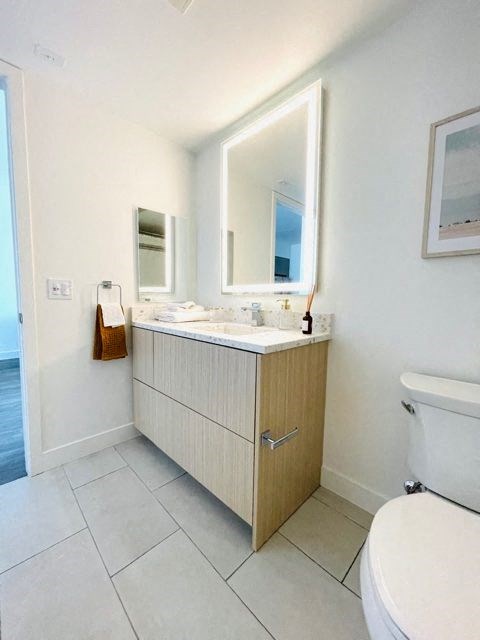 a bathroom with a sink toilet and a mirror