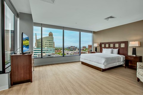 A bedroom with a large bed and a view of the city.