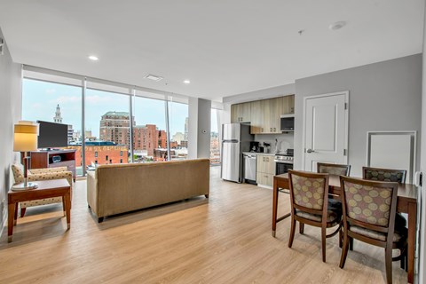 A living room with a couch, chairs, and a view of the city.