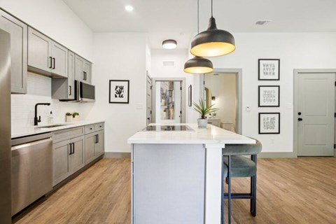 A modern kitchen with a white island and stainless steel appliances.