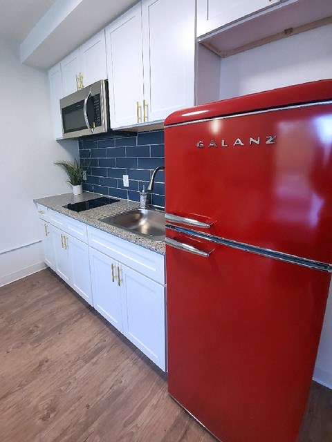 a kitchen with a red refrigerator and a sink