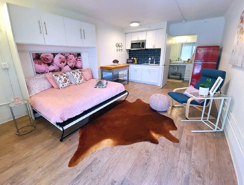 a bedroom with a bed and a rug on the floor