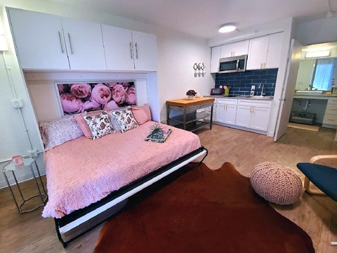 a bedroom with a bed and a kitchen