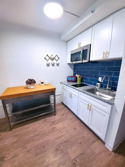 a small kitchen with a wooden table and a sink
