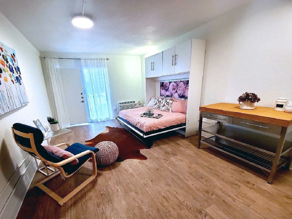 a bedroom with a bed and a desk in a small room