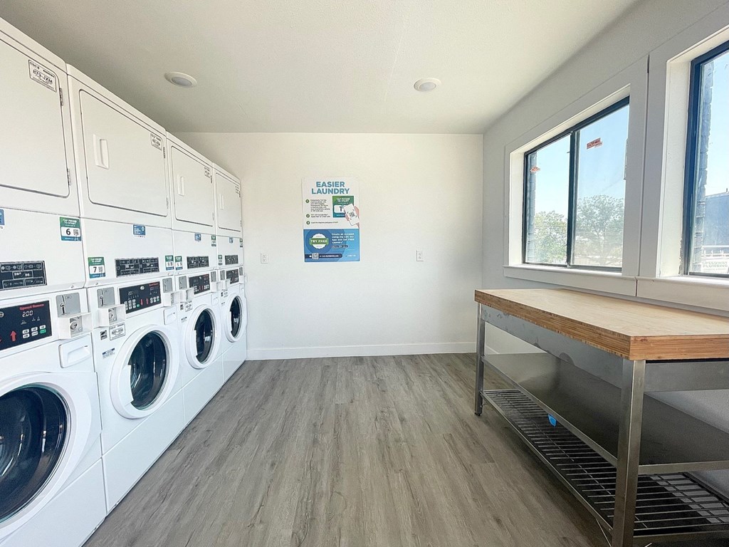 a laundry room with washer and dryers and a table