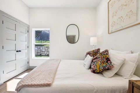 A bedroom with a large bed and a mirror on the wall.