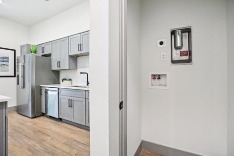 A kitchen with a refrigerator, sink, and cabinets.
