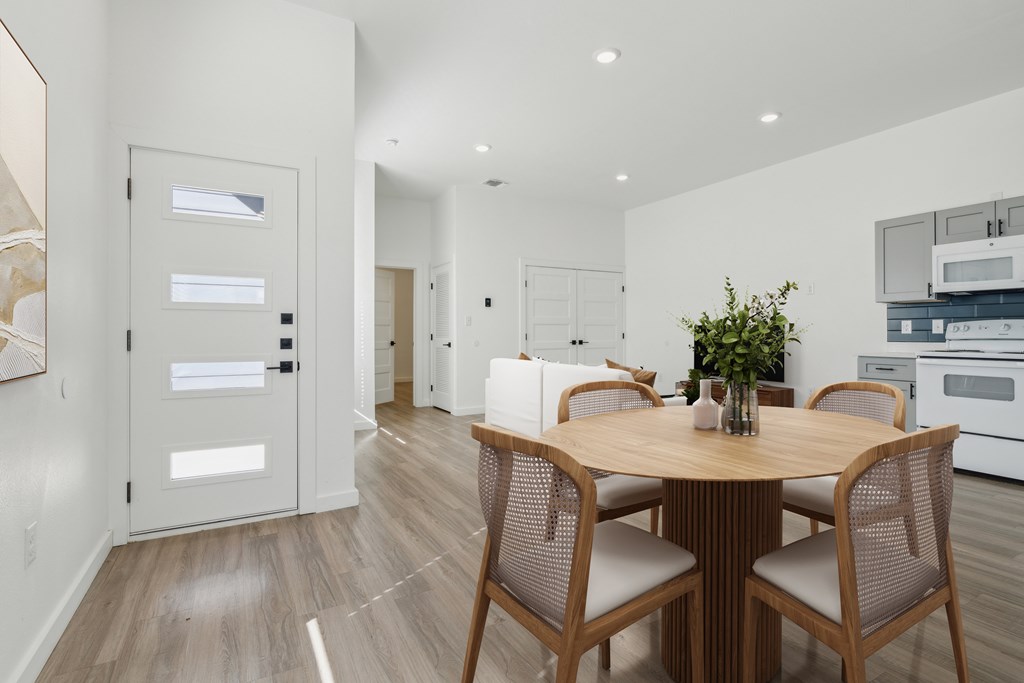 A modern dining room with a wooden table and chairs.