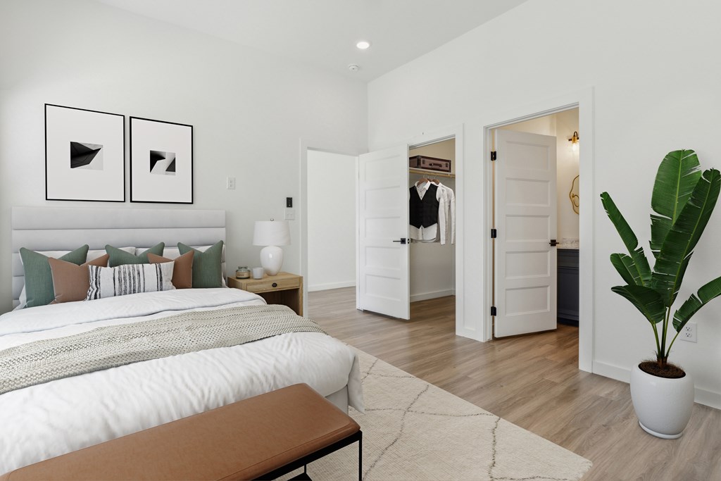 A bedroom with a large bed and a bench in the foreground.