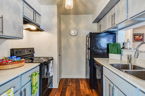 a kitchen with stainless steel appliances and a black refrigerator