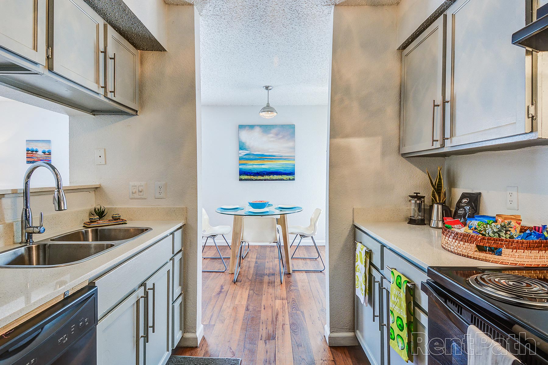 a kitchen with white cabinets and a sink and a table with a chair