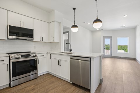 A kitchen with white cabinets and a stainless steel dishwasher.