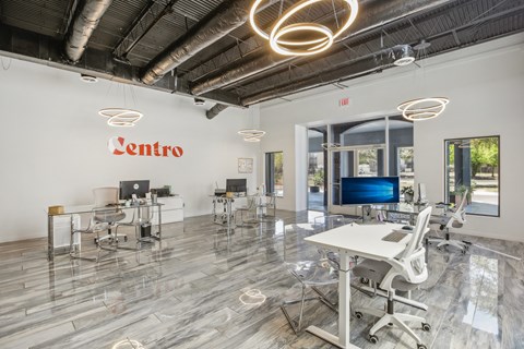 an open office space with desks and chairs and a tv