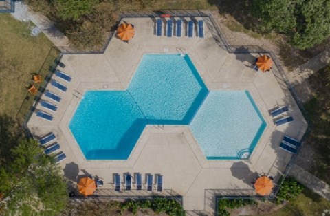 an aerial view of a swimming pool with umbrellas