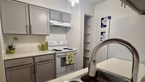 A kitchen with a stove, oven, and sink.