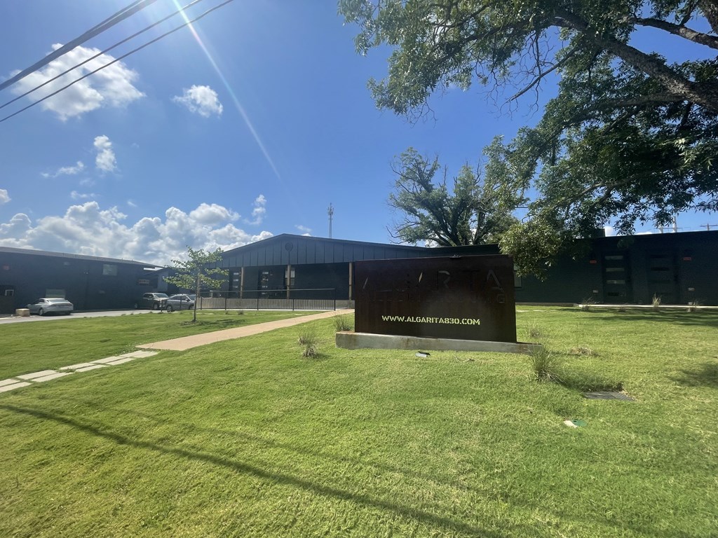 a building with a sign in front of a grass field